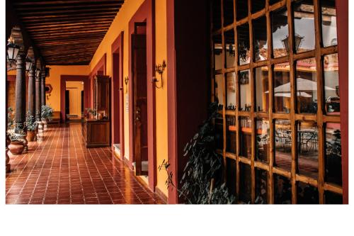 a hallway of a building with a room with windows at Hotel Diego de Mazariegos in San Cristóbal de Las Casas