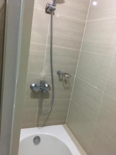 eine Dusche im Bad mit WC in der Unterkunft De Luxe 7QRS in Manila