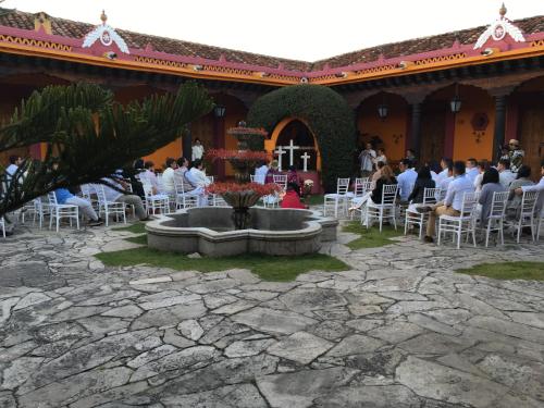 a group of people sitting at tables in a courtyard at Hotel Diego de Mazariegos in San Cristóbal de Las Casas