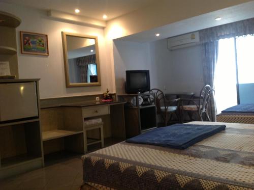 a hotel room with two beds and a television at Pension Zum Ross in Karon Beach