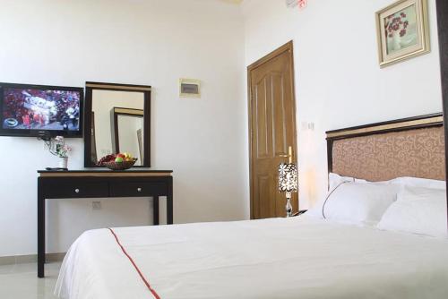 
a hotel room with a bed and a television at Golden Rose Hotel in Aqaba

