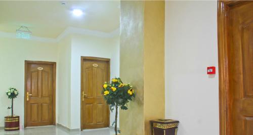 
a white vase filled with flowers next to a door at Golden Rose Hotel in Aqaba
