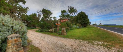 a dirt road with a sign on the side of the road at Stanley Lakeside Spa Cabins in Stanley