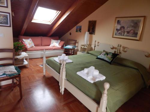 a bedroom with a green bed and a couch at Casa Vacanze Le Kenzie in Riposto