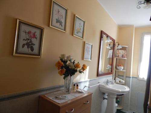 un bagno con lavandino e vaso di fiori di Casa Vacanze Le Kenzie a Riposto