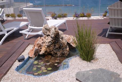 a rock pond with a chair and a chair at Maxim Design Hotel 3 Star Superior in Tel Aviv