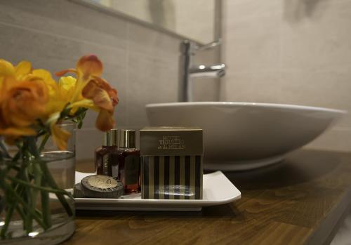 a bathroom counter with a sink and a vase of flowers at Hotel Tigullio Et De Milan in Santa Margherita Ligure
