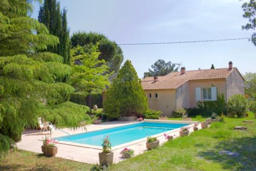 une grande piscine devant une maison dans l'établissement Les murmures du Temps Villa 3 Chambres avec Piscine, à Carpentras