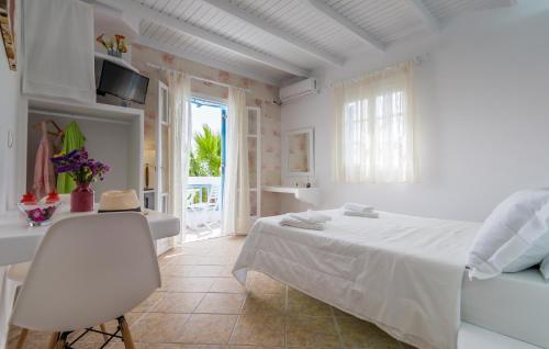 a white bedroom with a bed and a window at Orizontes Boutique Studios in Adamantas
