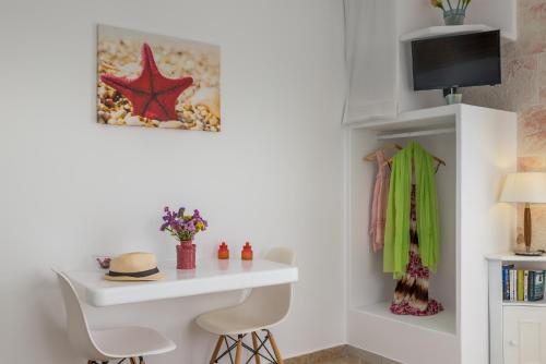 a room with a white desk and a table with chairs at Orizontes Boutique Studios in Adamas
