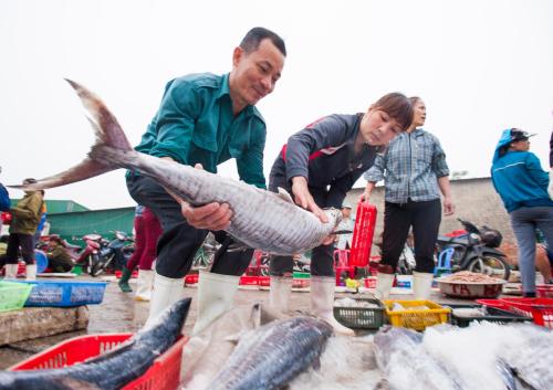 a man and a woman holding a large fish at Thanh Tu Hotel in Cửa Lò