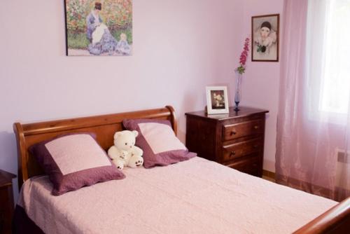 - un ours en peluche assis sur un lit dans une chambre dans l'établissement Les murmures du Temps Villa 3 Chambres avec Piscine, à Carpentras