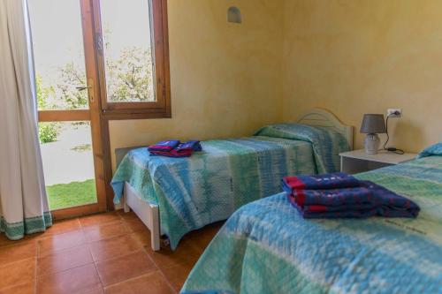 Habitación con 2 camas y ventana en Appartamento Baja Sardinia, en Baja Sardinia