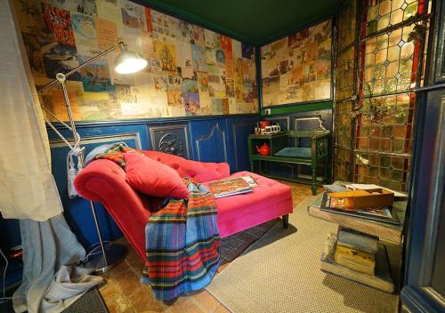 a room with a red couch with a blanket on it at Au2 Maison d'Hôtes - Guest House Au2 in Muidorge