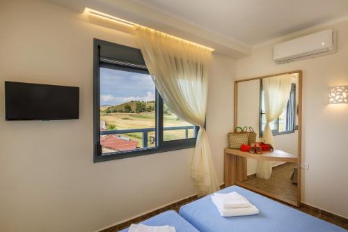 ein Schlafzimmer mit einem Fenster, einem TV und einem Bett in der Unterkunft Marialena Hotel in Flogita