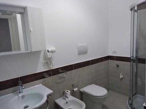 La salle de bains est pourvue de toilettes, d'un lavabo et d'une douche. dans l'établissement Casa Vacanze A Due Passi Dal Mare, à Porto Empedocle