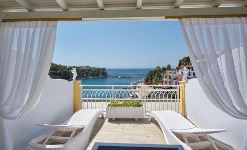 a balcony with chairs and a view of the ocean at Pension Votsi in Votsi