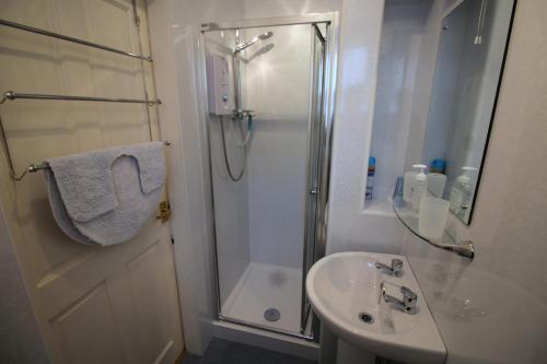 une salle de bain avec douche et lavabo dans l'établissement Easdale House Apartments, à Inverness