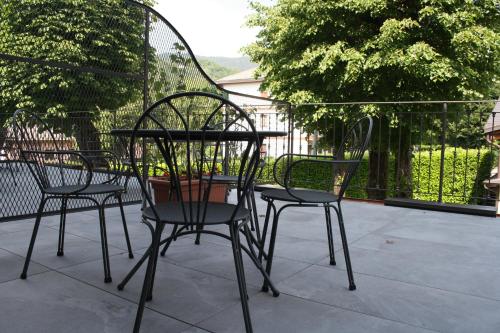 three chairs and a table on a patio at Hotel La Torre in Castiglione dʼIntelvi