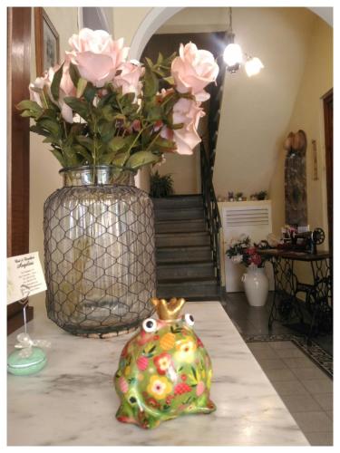 a vase filled with pink roses sitting on a table at BeB Angelini dal 1911 in Lucca