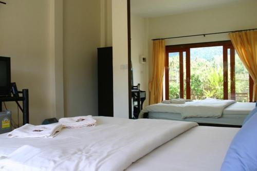 1 dormitorio con 2 camas y ventana en Naga Peak Resort, en Ao Nang Beach