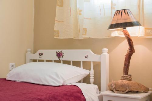 a bedroom with a bed with a lamp on a table at Fiora Villas in Trapezaki