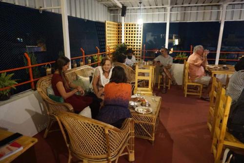 grupa ludzi siedzących przy stole w restauracji w obiekcie Silver Moon Guest House w mieście Mahabalipuram