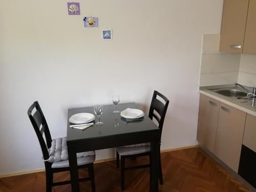 a dining room table with two chairs and a kitchen at Apartment Violeta 2 in Funtana