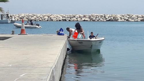 a woman and two children in a boat on the water at Marina's Rooms in Larnaka