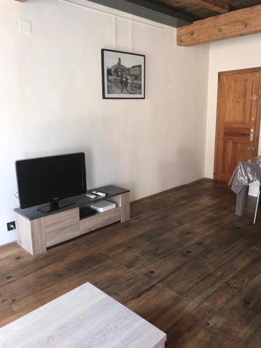 a living room with a flat screen tv and a wooden floor at Appartement L'Ile-Rousse in LʼÎle-Rousse