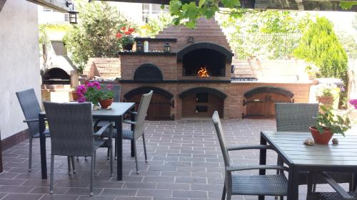 an outdoor patio with tables and chairs and a brick oven at Casa Lotca in Costinesti