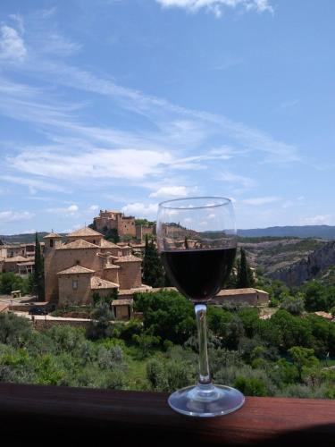 a glass of wine sitting on a table with a view at Hotel Santa Maria de Alquezar in Alquézar