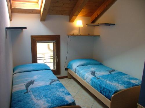 a bedroom with two beds and a window at San Pietro D'Orio Apartment in Grado