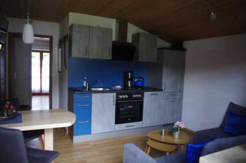 eine Küche mit blauen Schränken und einem Tisch im Zimmer in der Unterkunft Ferienwohnung Haus Alpenrebe in Schönau am Königssee