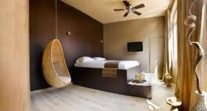 sypialnia z łóżkiem i wentylatorem sufitowym w obiekcie "Un Lieu Unique" Le Lodge et le Dolce w Annecy