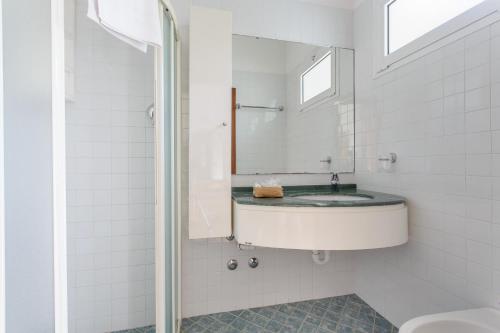 a white bathroom with a sink and a mirror at Casa Portofino Rooms&Breakfast in Cesenatico