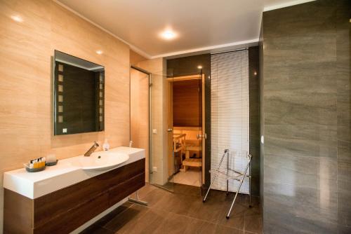 a bathroom with a sink and a mirror and a shower at Papli Villa in Pärnu