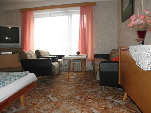 a living room with a couch and a table at Pension U Kaktusu in Karlovy Vary