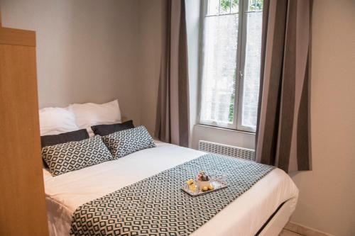 カルカソンヌにあるLE 139 carcassonneのベッドルーム1室(ベッド1台、食料品のトレイ付)