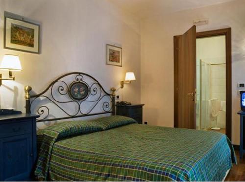 a bedroom with a large bed with a green blanket at Albergo La Bersagliera in Noventa di Piave