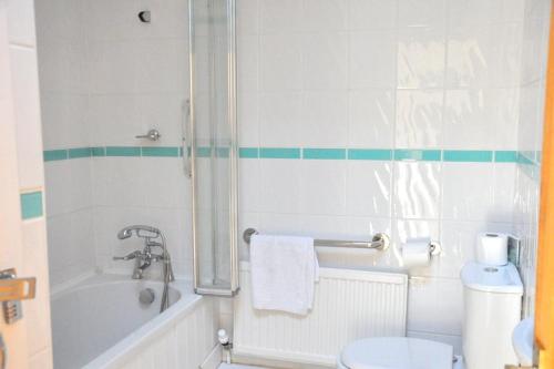 a bathroom with a shower and a tub and a toilet at Stunning Seaview Cottage in St Just