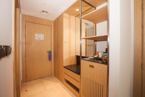 a small kitchen with a door and a counter at Flora Inn Hotel Dubai Airport in Dubai