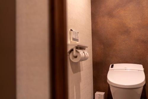 a bathroom with a toilet and a roll of toilet paper at Hotel Torifito Otaru Canal in Otaru