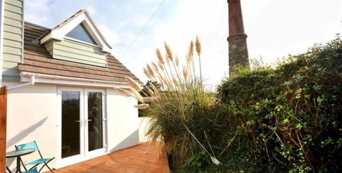 a white house with a porch and a patio at Little Fernleigh in Perranporth