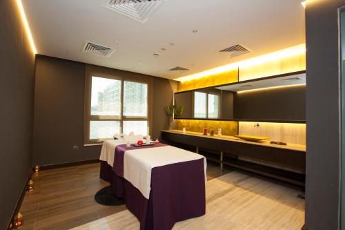 a room with a table and a bathroom with a sink at Flora Inn Hotel Dubai Airport in Dubai