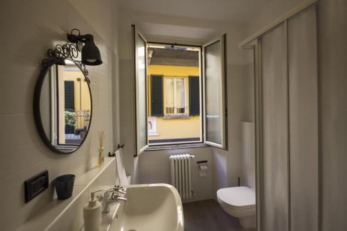 bagno con lavandino, servizi igienici e specchio di Appartamento Il Centro a Bellagio