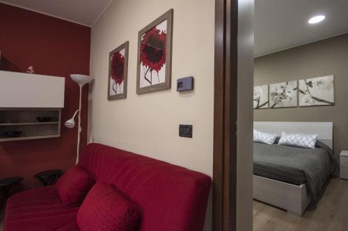 貝拉焦的住宿－Appartamento Il Centro，客厅配有红色的沙发和床。
