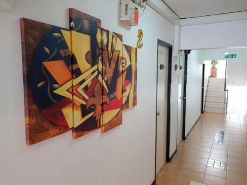 a painting hanging on a wall in a hallway at Casa Picasso Near Chabad House in Bangkok