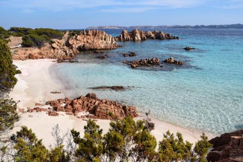 - une vue sur une plage avec des rochers dans l'eau dans l'établissement Casa Duminicheddha, mare e relax in Gallura, à Bassacutena