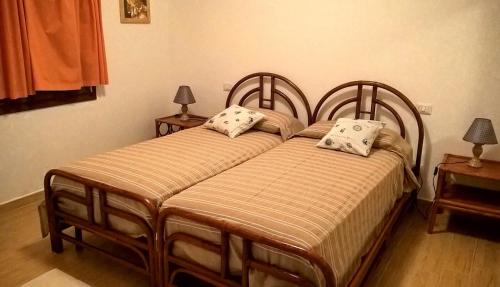 - deux lits jumeaux dans une chambre avec deux lampes dans l'établissement Casa Duminicheddha, mare e relax in Gallura, à Bassacutena